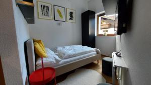 Habitación pequeña con cama y taburete rojo en FRANZ by Miha, en Westendorf