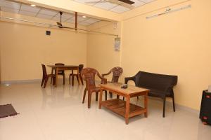 una sala d'attesa con tavoli e sedie in legno di Sunrise Home Stay a Port Blair