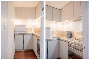 a kitchen with white cabinets and white appliances at Stylish Flat in the heart of South Kensington in London