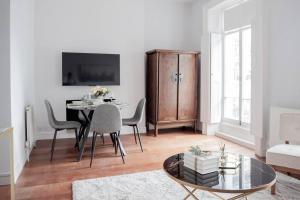 a living room with a table and chairs and a cabinet at Stylish Flat in the heart of South Kensington in London