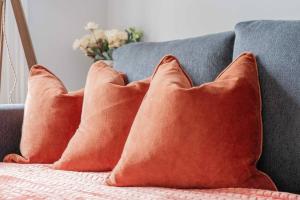 a group of orange pillows on a couch at Stylish Flat in the heart of South Kensington in London