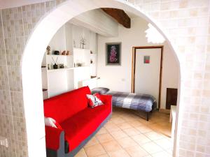 a living room with a red couch and a bed at Confortevole Appartamento Il Sorriso piano terra ingresso e parcheggio indipendente per una tranquilla privacy in Lugo