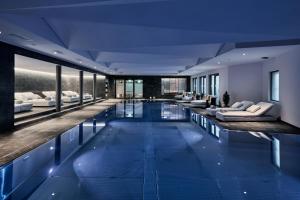 a large swimming pool with couches and chairs in a building at Hotel GRACE LA MARGNA ST MORITZ in St. Moritz