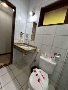 een badkamer met een toilet, een wastafel en een spiegel bij Pousada Villa N'kara in Itacaré