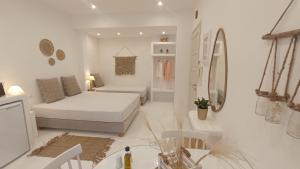 biała sypialnia z łóżkiem i lustrem w obiekcie Evdion Naxos Town w mieście Naksos