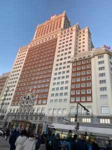 a large building with people standing in front of it at Luxury private Flat City Center, AC & Parking gratuito in Madrid