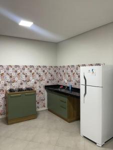 eine Küche mit einem weißen Kühlschrank im Zimmer in der Unterkunft Apartamento com vista para palco festival in Chapada dos Guimarães