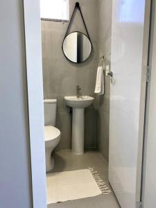 a bathroom with a toilet and a sink and a mirror at Loft 116 B - Porto Belo/SC in Porto Belo +10 photos