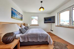 a bedroom with a bed and a flat screen tv at Sunshine Apartment Wood'n Rustic in Garmisch-Partenkirchen