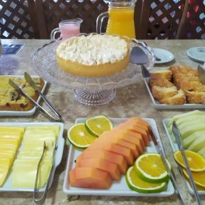 a table topped with plates of cheese and a cake at Pousada Castelo do Rei in Penha
