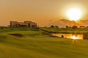 uma vista para um campo de golfe com o pôr-do-sol ao fundo em Eleganza Suites em Kilifi