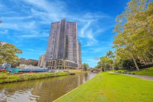 a tall building next to a river in a city at Entire home with parking in Parramatta in Sydney