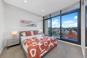 a bedroom with a bed and a large window at Entire home with parking in Parramatta in Sydney