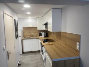 een keuken met witte kasten en een houten aanrecht bij Appartement Sol y Mar in Saint-Aygulf