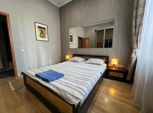 Un dormitorio con una cama grande con una toalla azul. en Apartment Lesya Kurbasa, en Leópolis