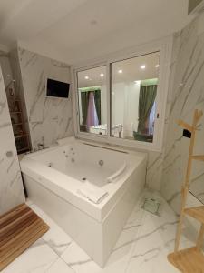 baño blanco con bañera y espejo grande en Babylon Luxury Suite & Apartments, en Nápoles