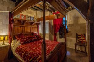 een slaapkamer met een hemelbed en een rood dekbed bij Appartement du Sorcier Magique expérience & Parking in Dijon