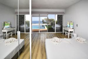 two views of a bedroom with a view of the ocean at Ocean Island Villa in Achlia