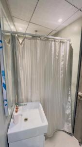 uma casa de banho com uma cortina de chuveiro branca e um lavatório. em Interstellar View at 22nd Floor em Nova Deli