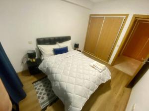 um quarto com uma cama branca e uma almofada azul em Chic & Cosy au coeur d’hivernage em Marrakech