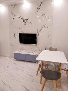 a living room with a tv and a white table at Luxury new very beautyfull Apartment in Yerevan