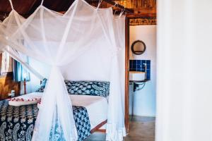 a bedroom with a bed with a canopy at Baobab Beach Vilanculos in Vilanculos