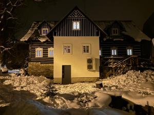 Boutique Cottage Tkalcovna في روكيتنسي ناد جيزيرو: منزل في الثلج في الليل