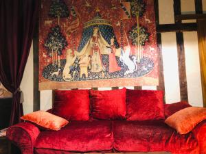 - un canapé rouge dans le salon orné d'une peinture murale dans l'établissement "appartementdusorcier" Magique expérience & Parking, à Dijon