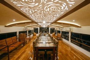 a long dining room with a long table and benches at Honeymoon Houseboat in Alleppey