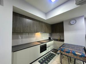 een keuken met witte kasten en een klok aan de muur bij Datum Jelatek Sky Resident KLCC by Deen in Kuala Lumpur
