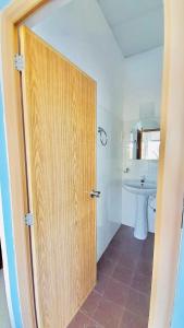 a door to a bathroom with a toilet and a sink at Blossom Rest in Kandy