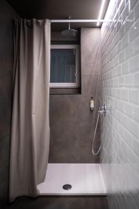 a bathroom with a shower with a shower curtain at Hostelò - Luxury Hostel in Palermo