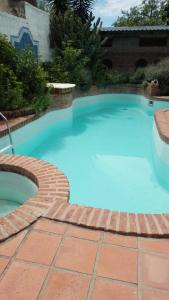 ein großer blauer Pool mit einem Ziegelweg um ihn herum in der Unterkunft Hermosa casa con parque in Cordoba