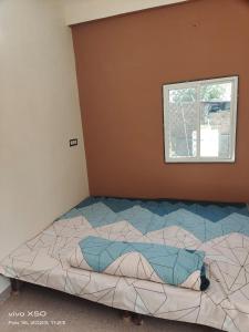 uma cama grande num quarto com uma janela em Kavya Home stay em Ujaim