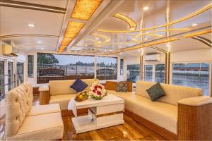 a living room on a boat with couches and a table at Double Decker Houseboat in Alleppey