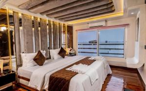 a bedroom with a large bed with a large window at Double Decker Houseboat in Alleppey