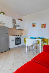una cucina con divano rosso e tavolo con sedie di Le Piscine RELAX a Nardò