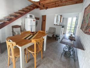 Una cocina y un comedor con mesa y sillas de madera. en Complejo Hermoseño - by Me Nomad, en Monte Hermoso
