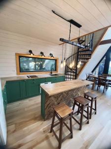 a kitchen with green cabinets and a table and chairs at The Sunset Cabin будиночок з Чаном in Zhuraky