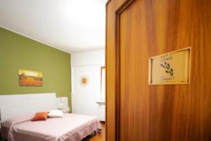 a bedroom with a bed and a door to a room at B&B GREEN HOUSE in Cascina
