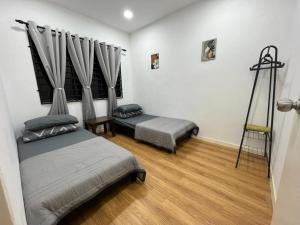 1 dormitorio con 2 camas y escalera en ZR HOLDFAST HOMESTAY BUKIT KATIL MELAKA, en Kampong Bukit Beruang