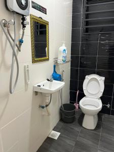 y baño con aseo y lavamanos. en ZR HOLDFAST HOMESTAY BUKIT KATIL MELAKA, en Kampong Bukit Beruang
