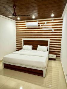 1 dormitorio con 1 cama grande y pared de madera en Hotel Walk Inn en Faridabad