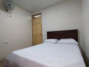 1 dormitorio con 1 cama con cabecero de madera y ventana en Papaturro House, en La Cruz