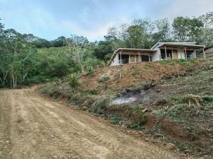 una casa al lado de un camino de tierra en Papaturro House, en La Cruz