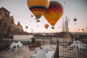 un grupo de globos de aire caliente volando en el cielo en DAPHNE CAVE HOTEL, en Avanos