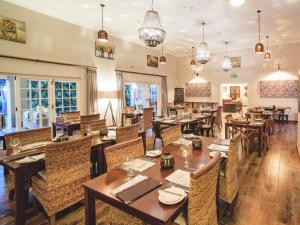 a restaurant with wooden tables and chairs at Monkey Thorn Guest Lodge in White River