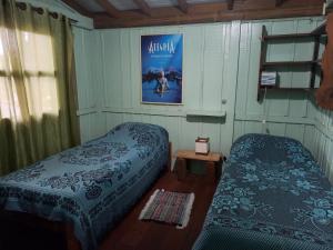 Zimmer mit 2 Betten und einem Filmplakat an der Wand in der Unterkunft casa do morro linda vista para ate 08 pessoas in Imbituba