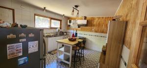 a kitchen with a refrigerator and a table in it at Amplia Casa 6-8 personas, Sector tranquilo in Dalcahue