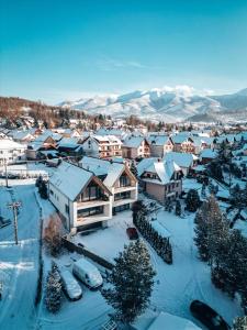 a town covered in snow with mountains in the background at JAMY HOUSE Apartmán in Habovka